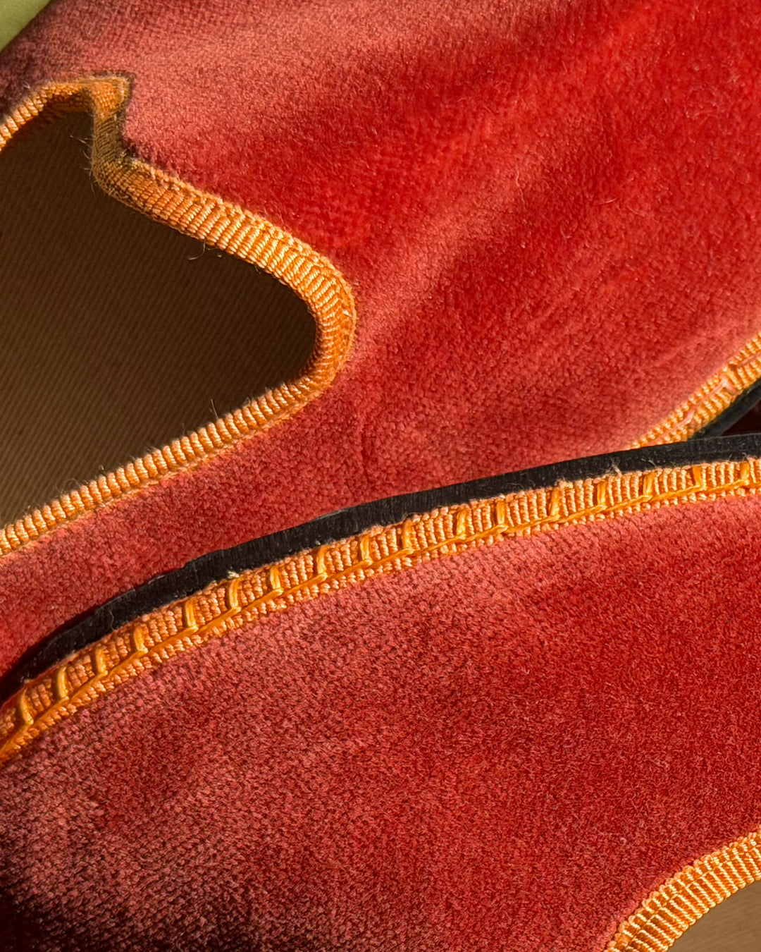 Detail of the terracotta velvet and hand-stitched amber grosgrain trim of the Ambra Friulane