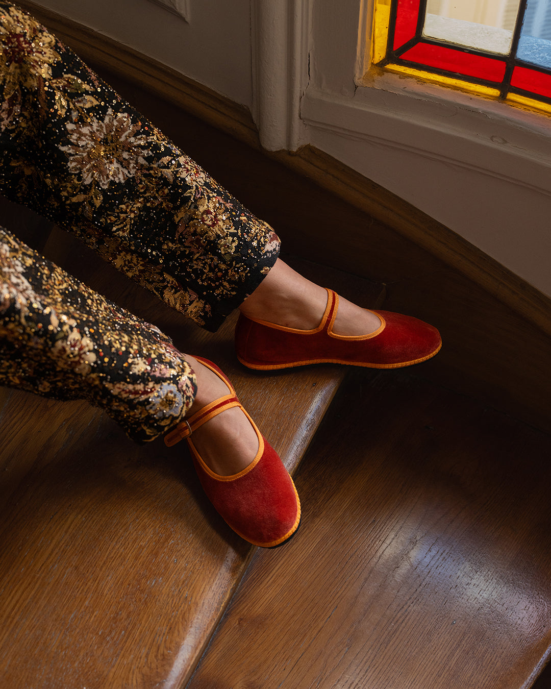 Tamu Mary Jane Friulane in terracotta velvet with clementine orange trim, worn with printed trousers.