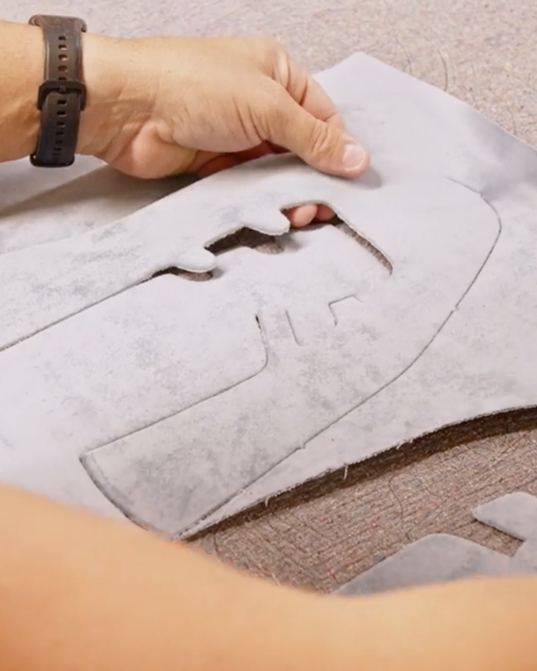 Artisan cutting the pattern for a handmade double Mary Jane friulane in light blue Italian velvet